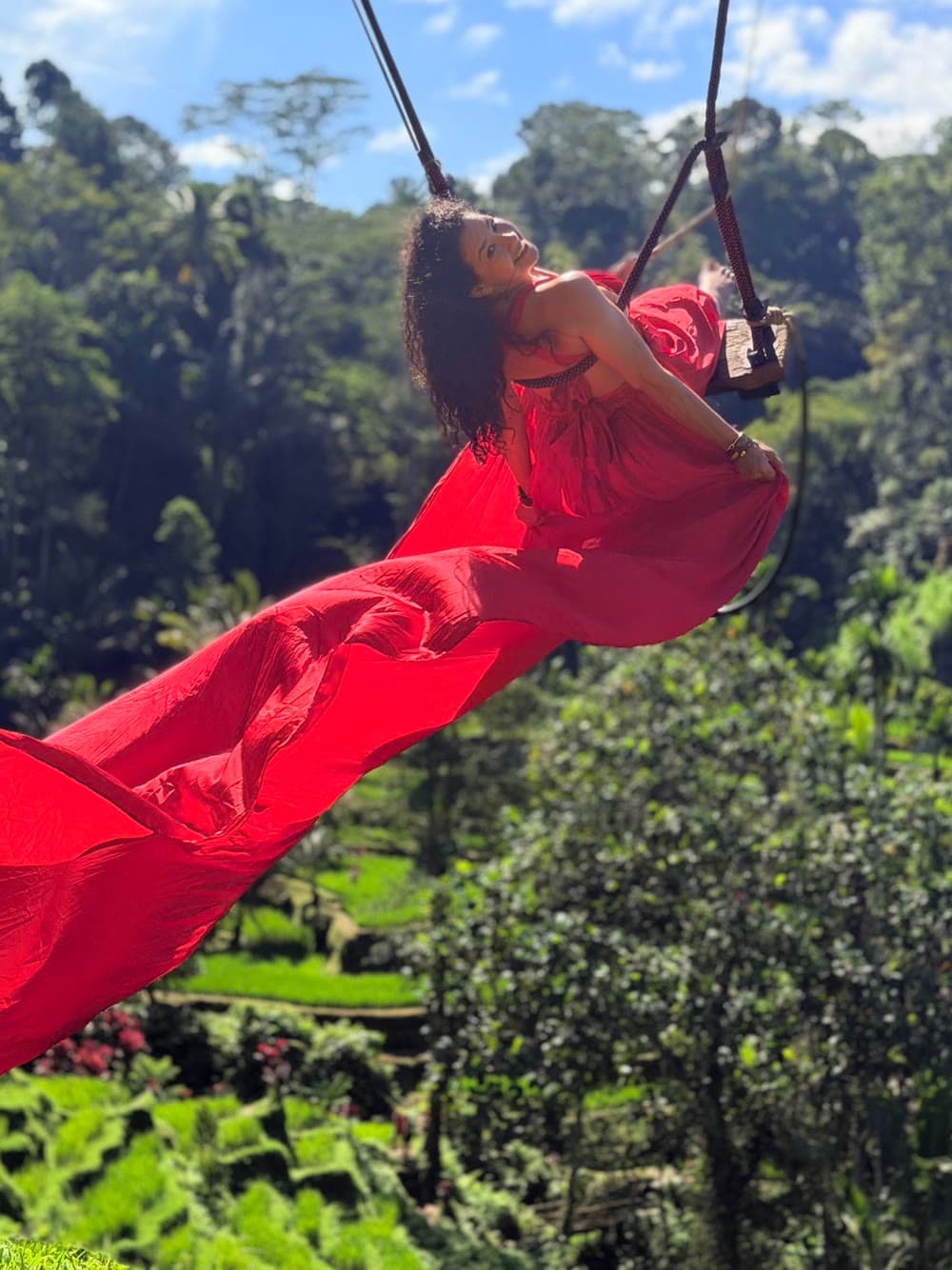Cynthia columpiándose con alegría sobre un frondoso paisaje de selva