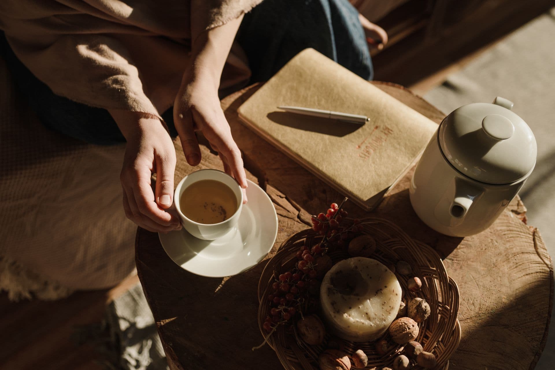 Un momento cálido y tranquilo con té y un diario bajo luz suave de la tarde